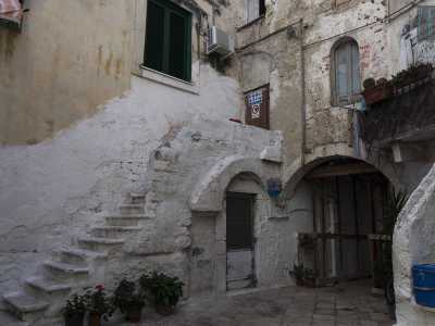 ...lo spiazzo si insinua a fatica tra palazzine romaniche e strette scalinate: una di esse non ha neanche il corrimano...